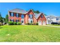 Traditional two-story red brick home with an attached two-car garage and a green lawn at 5125 Winding Glen Dr, Lithonia, GA 30038