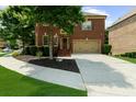 Charming brick home with a well-manicured front yard and attached two-car garage at 3086 Frazier Walk, Decatur, GA 30033
