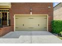 Attached two car garage with light beige doors and black hardware at 3086 Frazier Walk, Decatur, GA 30033