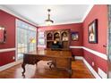 Red office featuring classic wood desk, shelving, and hardwood flooring at 4115 Gold Mill Rdg, Canton, GA 30114
