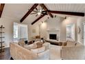 Cozy living room with vaulted ceilings, exposed beams, a fireplace, and neutral-toned furniture at 3070 Ascot Ln, Roswell, GA 30076
