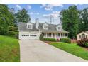 Charming two-story home with a welcoming front porch, two-car garage, and beautiful landscaping at 1624 Glenfield Dr, Lawrenceville, GA 30043