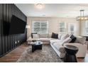 Modern living room with stylish wood accent wall, plush sofa, and ample natural light from large windows at 2039 Wildflower Nw Way, Conyers, GA 30012