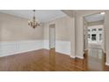 Traditional dining room with wainscoting, hardwood floors, chandelier, and views to the backyard at 5040 Stonehaven Vw, Cumming, GA 30040