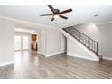 Bright living room with staircase, ceiling fan, hardwood-style floors, and view into the kitchen at 7 Villa Se Ct, Smyrna, GA 30080