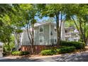 Charming condo exterior featuring mature trees, light gray facade, and well-maintained landscaping at 1450 Keys Crossing Ne Dr, Brookhaven, GA 30319