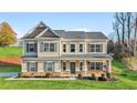 Beautiful two story home with manicured lawn, featuring a covered front porch and neutral siding at 200 Cherokee Reserve Cir, Canton, GA 30115