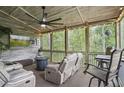Comfortable screened-in porch with rustic decor, TV, ceiling fan, and a view of the wooded backyard at 421 Retreat Ln, Canton, GA 30114
