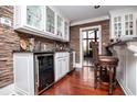 Stylish bar area with custom cabinets, granite countertops, wine cooler, and brick backsplash at 1050 Denton Rd, Douglasville, GA 30134