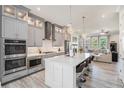 Open-concept kitchen with stainless appliances, large island, and stylish gray cabinetry at 710 Elmwood Way, Roswell, GA 30075