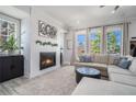 Cozy living room featuring a modern fireplace, plush seating, and bright windows with natural light at 710 Elmwood Way, Roswell, GA 30075