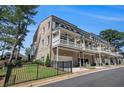 Townhome featuring a private, covered patio with a ceiling fan and a two-car garage, perfect for outdoor relaxation at 710 Elmwood Way, Roswell, GA 30075