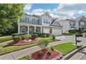 Two-story home with blue shutters, covered porch, brick accents, and a well-landscaped front yard at 1017 Preserve Park Dr, Loganville, GA 30052