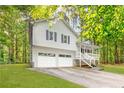Exterior shot of a two-story home featuring an attached garage, white siding, and a cozy front porch at 127 Danielle Ct, Villa Rica, GA 30180