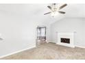 Cozy living room featuring plush carpeting, ceiling fan, fireplace, and an archway at 127 Danielle Ct, Villa Rica, GA 30180