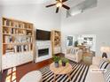 Bright living room with a fireplace, hardwood floors, and vaulted ceilings is staged with tasteful decor at 1503 Colt Ridge Se Ln, Mableton, GA 30126