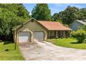 Charming one-story home featuring an attached two-car garage, mature trees, and a well-maintained lawn at 2617 Laurel Woods Se Ln, Conyers, GA 30094