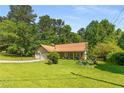 Charming one-story home featuring an attached two-car garage, mature trees, and a well-maintained lawn at 2617 Laurel Woods Se Ln, Conyers, GA 30094