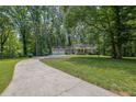 A picturesque home with an attached two-car garage, nestled amidst a lush, wooded landscape at 4516 Creekwood Circle Nw, Kennesaw, GA 30152