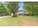 Traditional single-story home with a well-kept front yard, mature landscaping, and an attached two-car garage at 123 Chippewa Run, Auburn, GA 30011