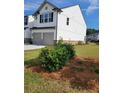 Side view of home with a two-car garage and landscaping at 3848 Hester St, Duluth, GA 30097