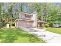 Two-story home with attached garage, circular window, and well-manicured lawn at 916 Forest Pointe Way, Jonesboro, GA 30238