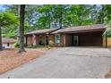 Traditional brick home with a covered carport and mature trees offering shade at 3431 Alcan Way, Tucker, GA 30084