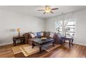 Cozy living room with elegant furniture, hardwood floors, a ceiling fan, and plenty of natural light at 823 Mackay Crk, Woodstock, GA 30188