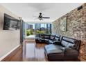 Modern living room with city views, a leather sectional, hardwood floors, and exposed brick accent wall at 3338 Peachtree Ne Rd # 508, Atlanta, GA 30326
