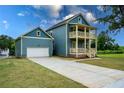 Charming two-story home features a double porch, blue siding, and an attached garage with a long driveway at 1993 Reynolds Sw Dr, Atlanta, GA 30315