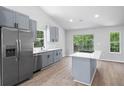 Modern kitchen with grey cabinets, stainless steel appliances, island and a large window showcasing the backyard at 3156 Ozmer Lndg, Decatur, GA 30034
