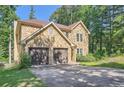 Side view of a stone-clad two-story home with a two-car garage and mature trees at 3005 Park Chase, Alpharetta, GA 30022