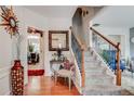 Inviting foyer showcases stairs with wood railing, decorative mirror, adjacent living spaces, and stylish decor at 3692 Ramsey Cir, Atlanta, GA 30331