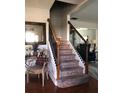 Elegant staircase with wooden banister and wrought iron spindles, carpeted steps to the upper level at 3692 Ramsey Cir, Atlanta, GA 30331