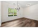 Light filled dining room with stylish light fixture and new wood flooring at 420 Berckman Nw Dr, Lilburn, GA 30047