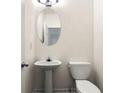 Clean and modern half bath with pedestal sink and oval mirror at 420 Berckman Nw Dr, Lilburn, GA 30047