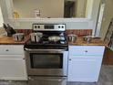 Stainless steel oven set in well-designed kitchen with wooden and white cabinetry at 929 Wexford Way, Auburn, GA 30011
