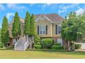 Charming two-story home with a landscaped front yard and symmetrical evergreen trees lining the front entrance at 147 Midland Dr, Stockbridge, GA 30281