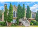 Charming two-story home with a landscaped front yard and symmetrical evergreen trees lining the entrance at 147 Midland Dr, Stockbridge, GA 30281