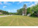 Expansive front yard with lush green grass and mature trees, offering ample space and curb appeal at 147 Midland Dr, Stockbridge, GA 30281
