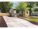 Well-maintained home with a charming stone exterior, a long driveway, fenced-in yard, and mature trees at 1130 Mclinden Se Ave, Smyrna, GA 30080