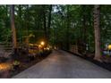 Long driveway with wooden gate entrance, lined with trees, and decorative lighting at 2230 Ewing Chapel Rd, Dacula, GA 30019