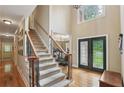 Grand foyer with staircase, hardwood floors, and elegant double doors at 315 Glengarry Chase, Covington, GA 30014