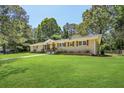 Well-maintained ranch home with brick exterior, lush lawn, and mature trees at 3301 Irish Ln, Decatur, GA 30032