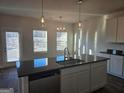 Spacious kitchen featuring modern stainless steel appliances, gray cabinetry, and stylish pendant lighting at 1672 Fuma Leaf Way, Mcdonough, GA 30252