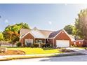 Beautiful brick home boasts mature trees, a manicured lawn, and an attached two-car garage at 381 Crossroads Dr, Social Circle, GA 30025