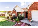 Inviting brick home featuring lovely landscaping, walkway, and an American flag display at 381 Crossroads Dr, Social Circle, GA 30025