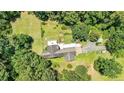 Aerial view of a home surrounded by a lush, green yard and mature trees at 3909 Laurens Ln, Snellville, GA 30039