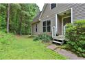 House exterior with covered porch, complemented by lush greenery and mature trees at 3909 Laurens Ln, Snellville, GA 30039