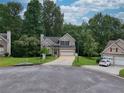 Inviting exterior view of a two-story home with a lush green lawn and attached garage, surrounded by mature trees at 4000 Mcpherson Drive, Acworth, GA 30101